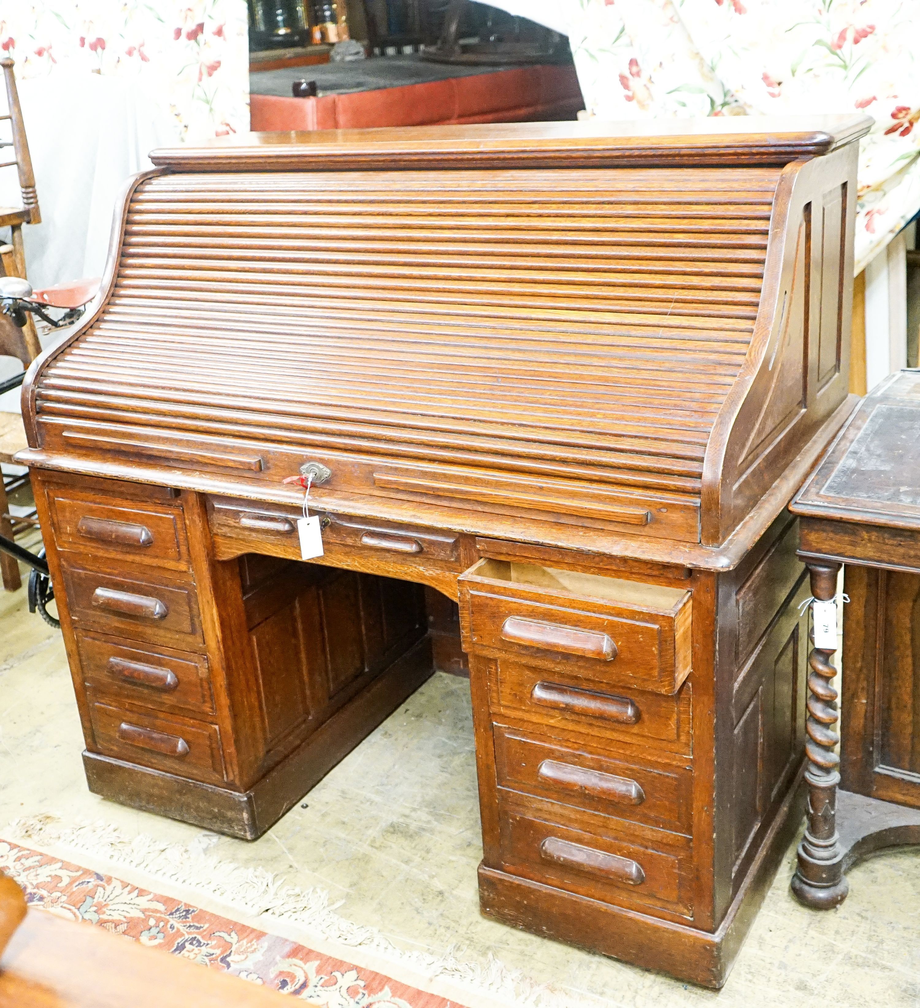 An early 20th century oak roll top desk with 'S' shape tambour, width 140cm, depth 80cm, height 128cm